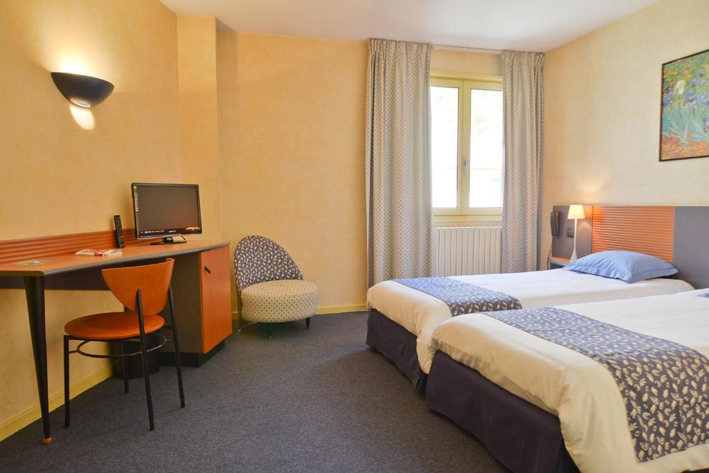 MontagnieuHotel Restaurant Rolland的酒店客房设有两张床和一张带电脑的书桌