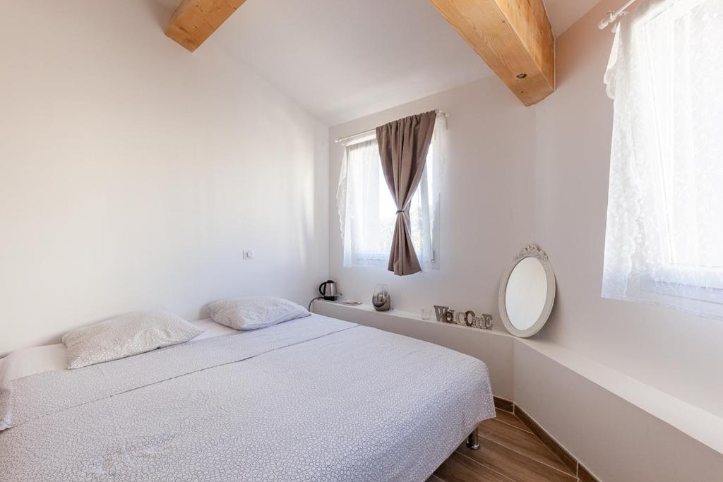 马赛Alpinias Bed and Breakfast的白色的卧室设有床和窗户