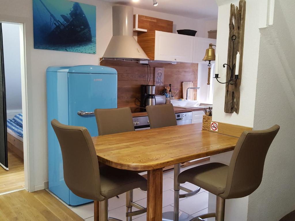 基尔Apartments Harmsstraße 13的厨房配有木桌和蓝色冰箱。
