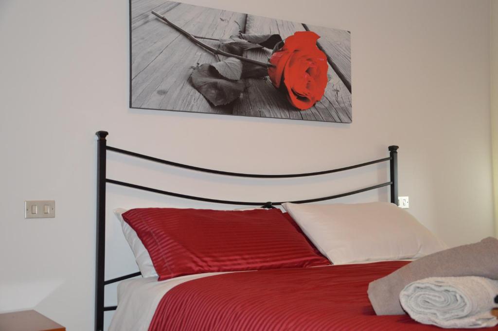 佩鲁贾Casa di Giulia的卧室配有红色的床,墙上挂有绘画作品