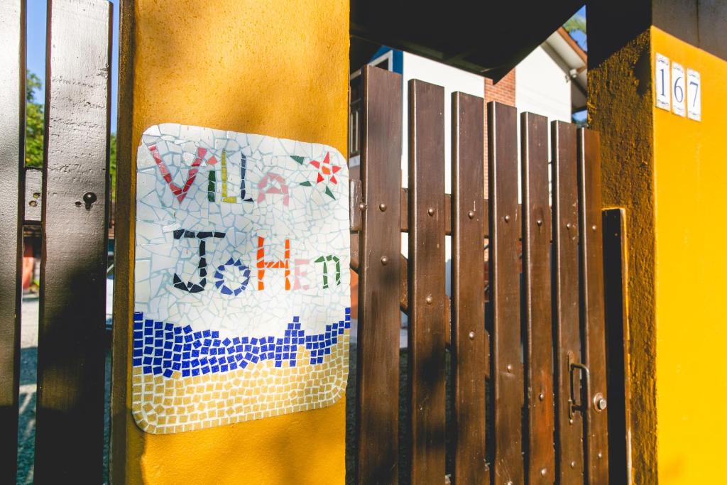 博西坎加Villa Johen的黄色墙边的标志