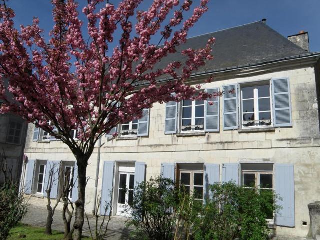 洛什La Closerie Saint Jacques的一座建筑物前有粉红色花的树