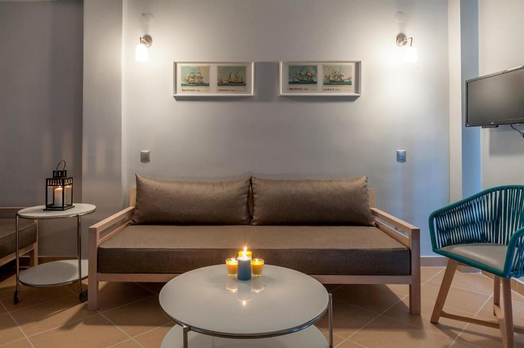 波利克罗诺Villa Despina Green Suites的客厅配有沙发和带蜡烛的桌子