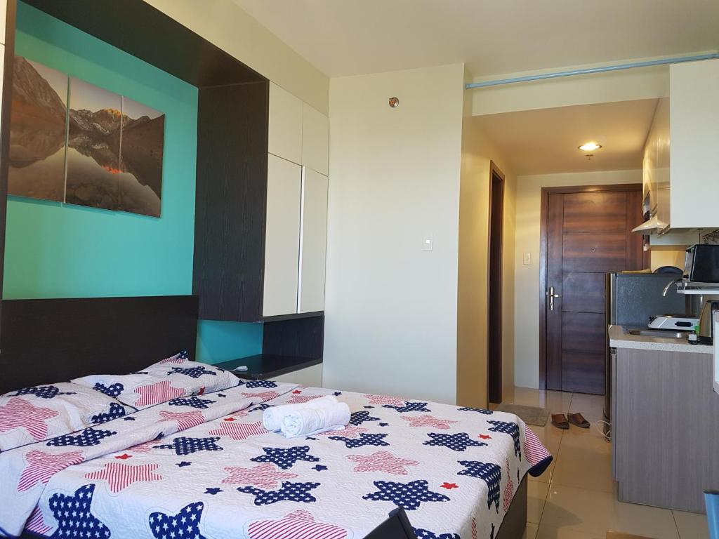 宿务Hermione's Haven at Horizon 101 Cebu的带厨房的客房内一间卧室,配有一张床