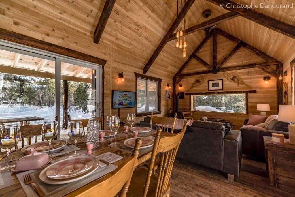 拉马巴耶Le Ross - Les Chalets Spa Canada的小木屋内的用餐室和客厅