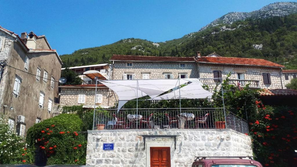 帕里斯特Guesthouse Žmukić的大楼内的阳台配有椅子和白色遮阳伞