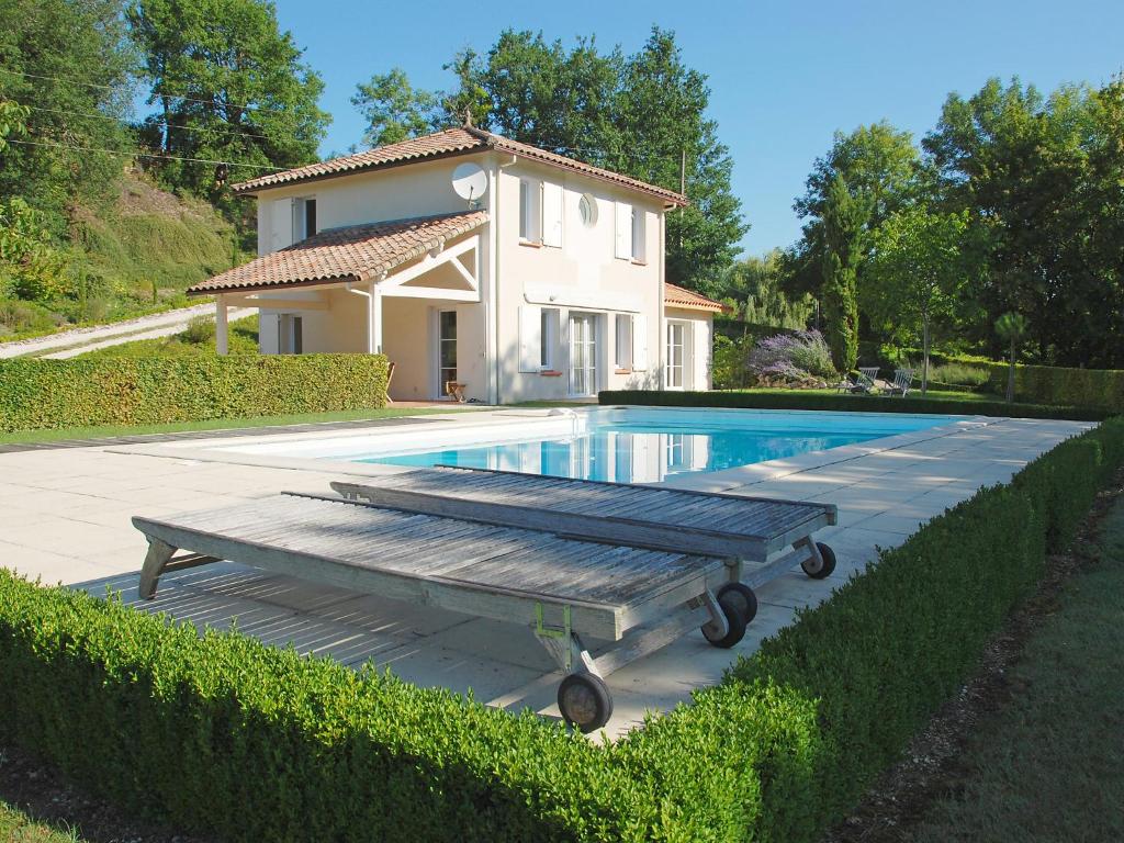 Saint-Pantaléon圣潘塔莱翁拉佩瑞尔度假屋的房屋和游泳池前设有长凳