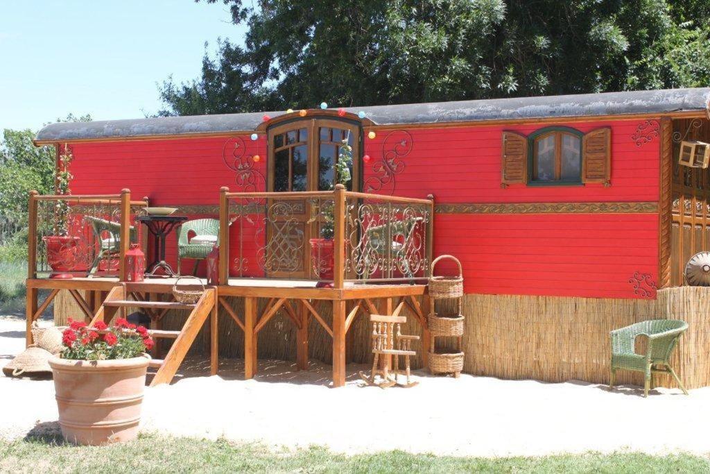 圣马迪拉莫拉如洛特“莱斯桑特”酒店的一辆红色火车车厢,带甲板和房子