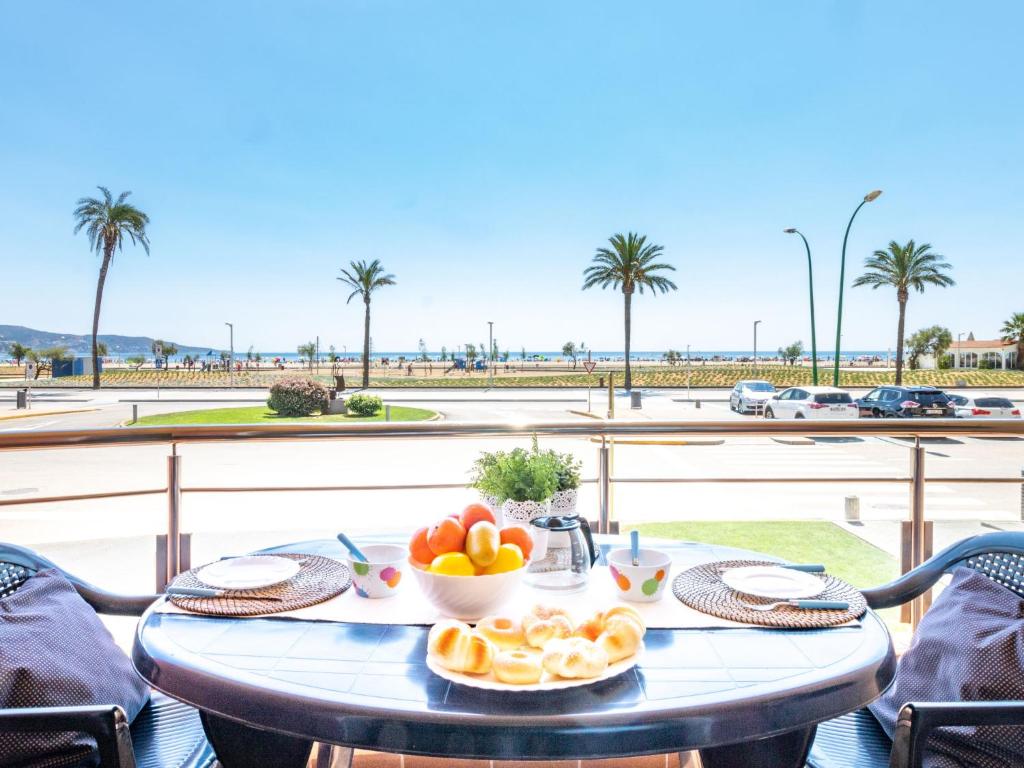 艾姆布里亚布拉瓦Apartment Edificio Blaucel by Interhome的一张桌子,放着一碗水果,享有海滩美景