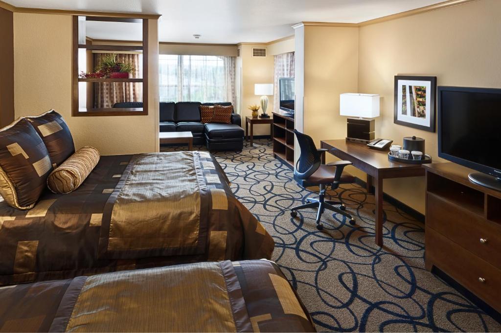 皮埃尔俱乐部之家套房酒店的酒店客房配有一张床、一张书桌和一台电视。