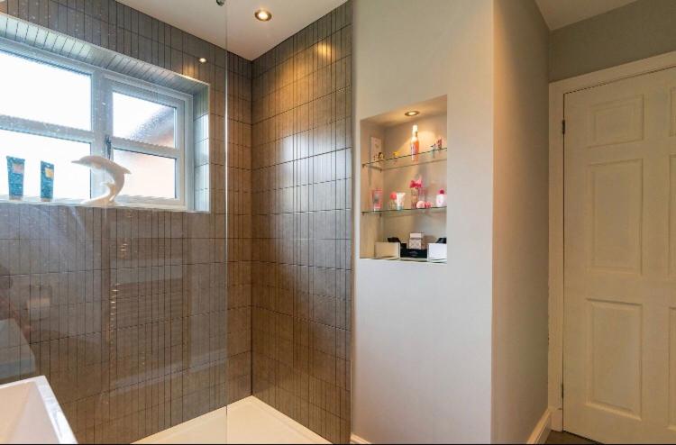 威姆斯洛Wilmslow Airbnb的带淋浴、水槽和窗户的浴室