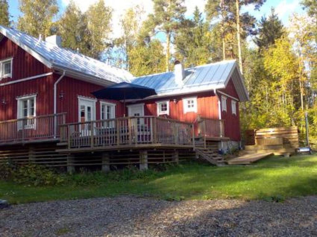 TallnäsHoliday Home Karri by Interhome的红色的房子,设有门廊和雨伞