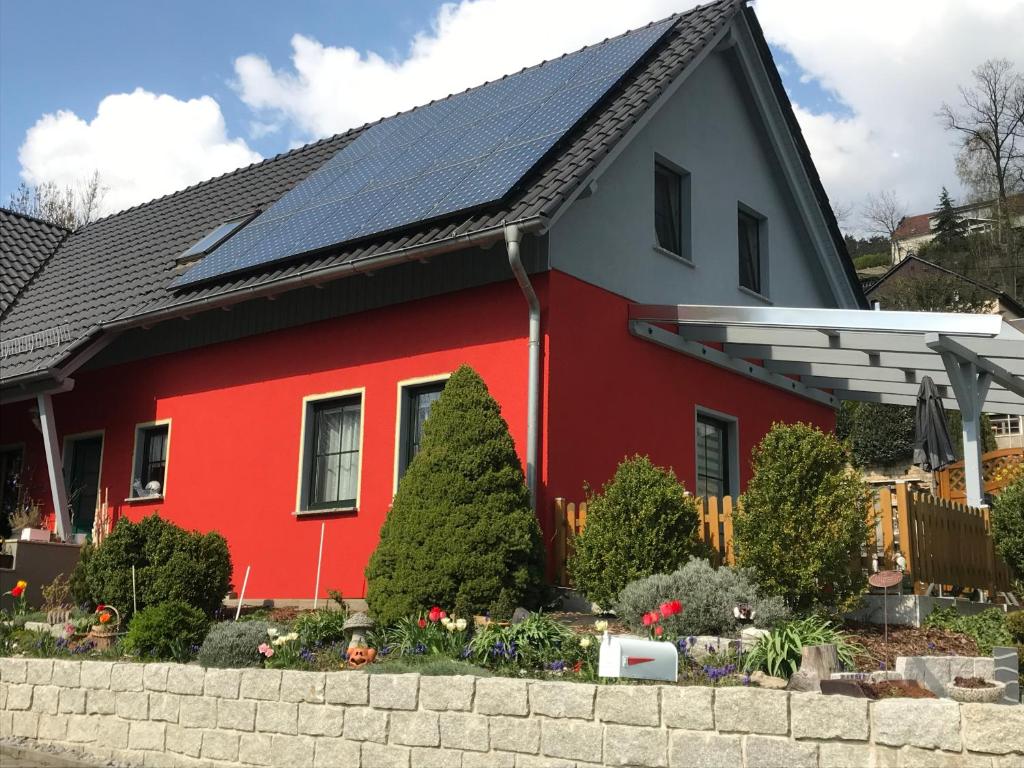 巴特尚道Fewo Ehrlich Sächs. Schweiz的屋顶上设有太阳能电池板的红色房子