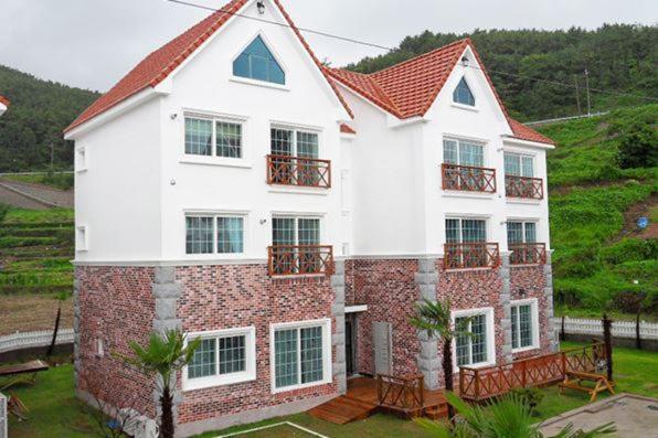 统营市Tongyeong Bada Sarang Pension的一座砖砌的白色大房子