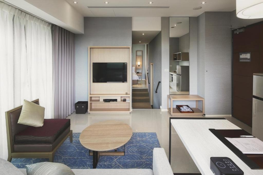 台北晴美公寓酒店的客厅配有电视、沙发和桌子