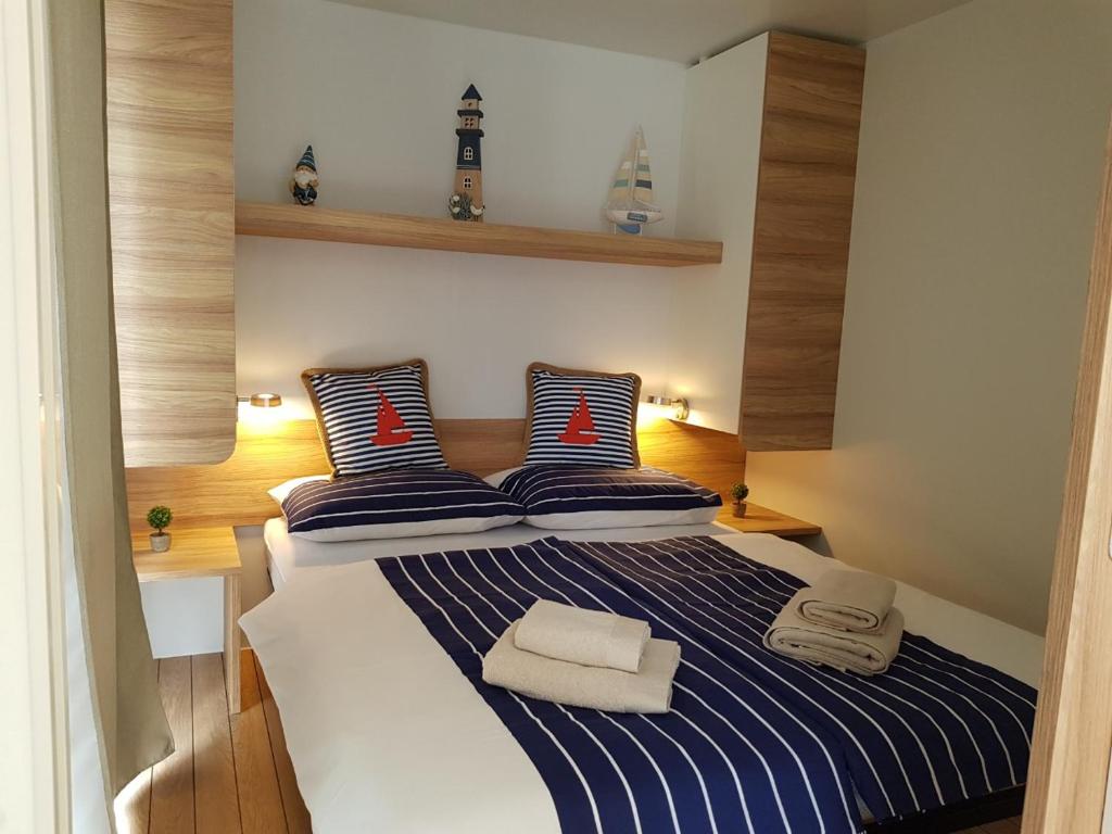 比奥格勒·纳·莫鲁Mobile Home Camping park Soline Gapi house的一间卧室配有一张蓝色和白色条纹的床