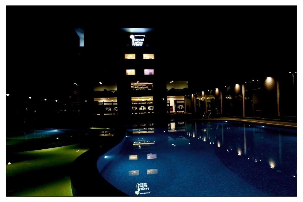 德瓦纳哈利-班加罗尔Royal Lotus View Resotel的一座高楼,晚上有一座游泳池