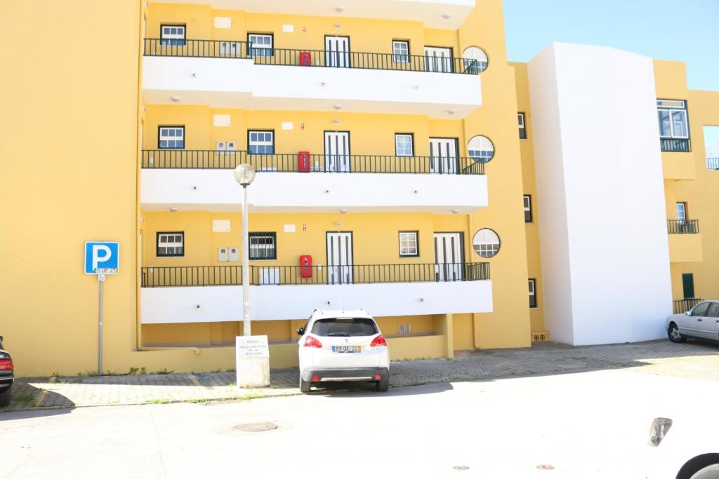 阿尔沃尔Apartamento Maria的停在黄色建筑前面的白色汽车