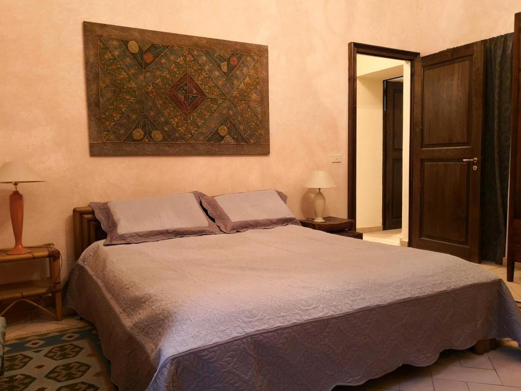 卡萨莱蒙费拉托San Giovannina '800的卧室配有一张床,墙上挂有绘画作品