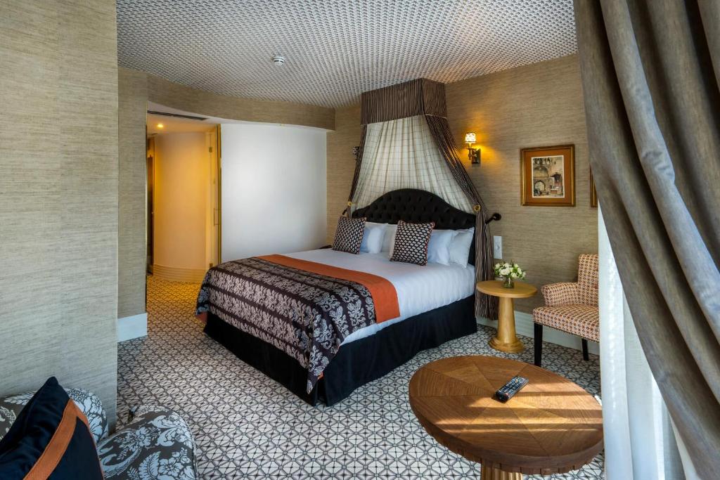 马德里The First One Madrid Preciados的酒店客房配有一张床铺和一张桌子。