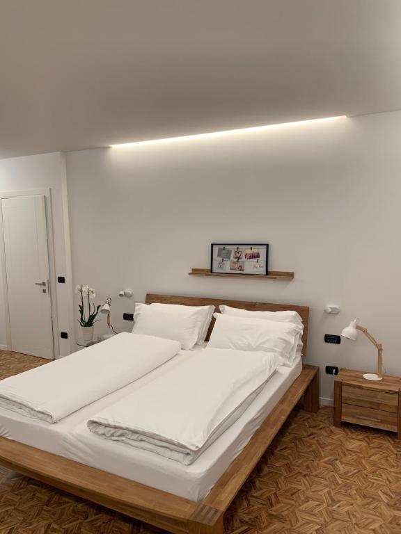 阿科Appartamenti Villa Sonia的卧室配有一张带白色床单和枕头的大床。
