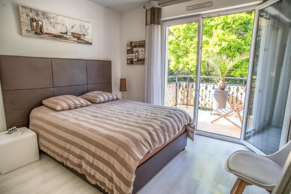 阿卡雄Appartement 90 m2 avec parking terrasse balcons, proche du port et plages的一间卧室设有一张床和一个阳台