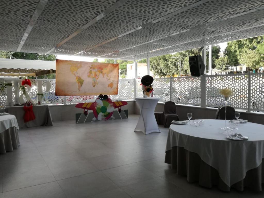 RusHostal El Sevillano的餐厅设有两张桌子,墙上挂着一幅画