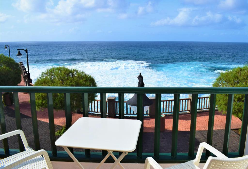 巴尔洛文托La Fajana Paradise的阳台配有白色的桌椅,享有海景。
