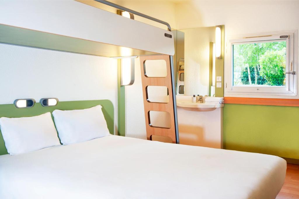 圣热尼拉瓦勒宜必思经济里昂南方圣格尼斯拉瓦尔酒店的一间卧室配有一张床、一个水槽和一张双层床。