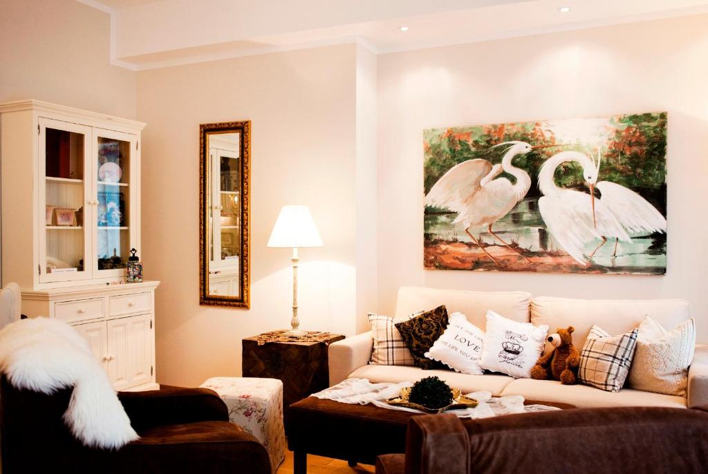 爱尔福特安睡在桥边公寓酒店的客厅配有沙发和天鹅绘画
