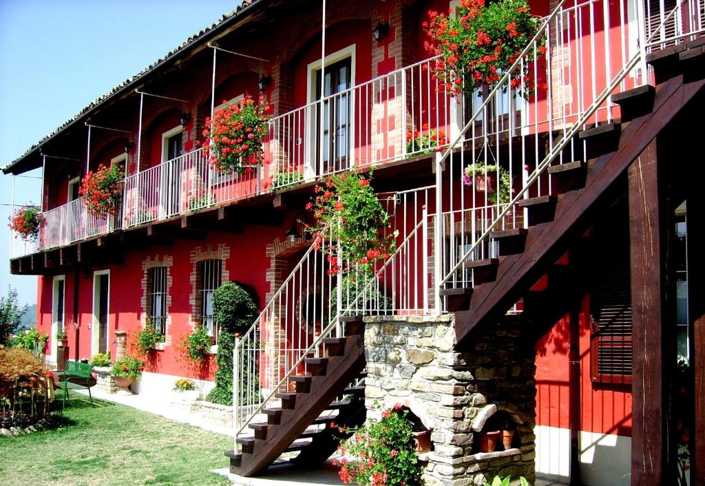 希尼奥布里科德尔加洛住宿加早餐旅馆的一座红色的建筑,阳台上放着花盒