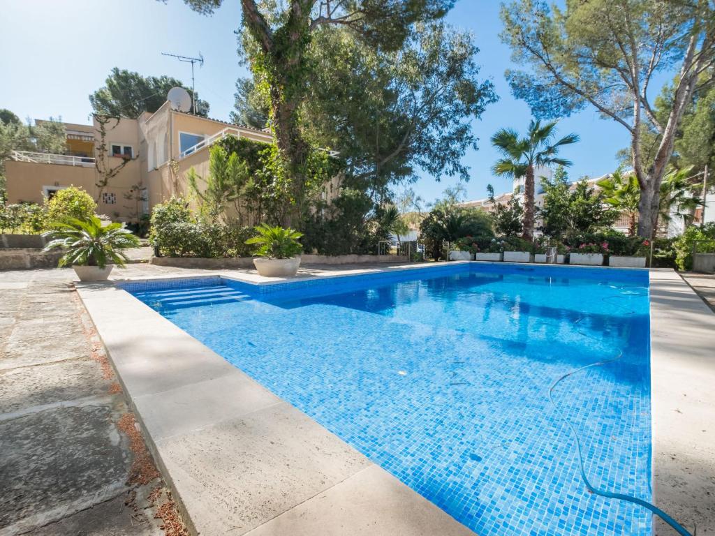 圣蓬萨Villa Santa Ponça by Interhome的一座树木繁茂的房屋前的游泳池