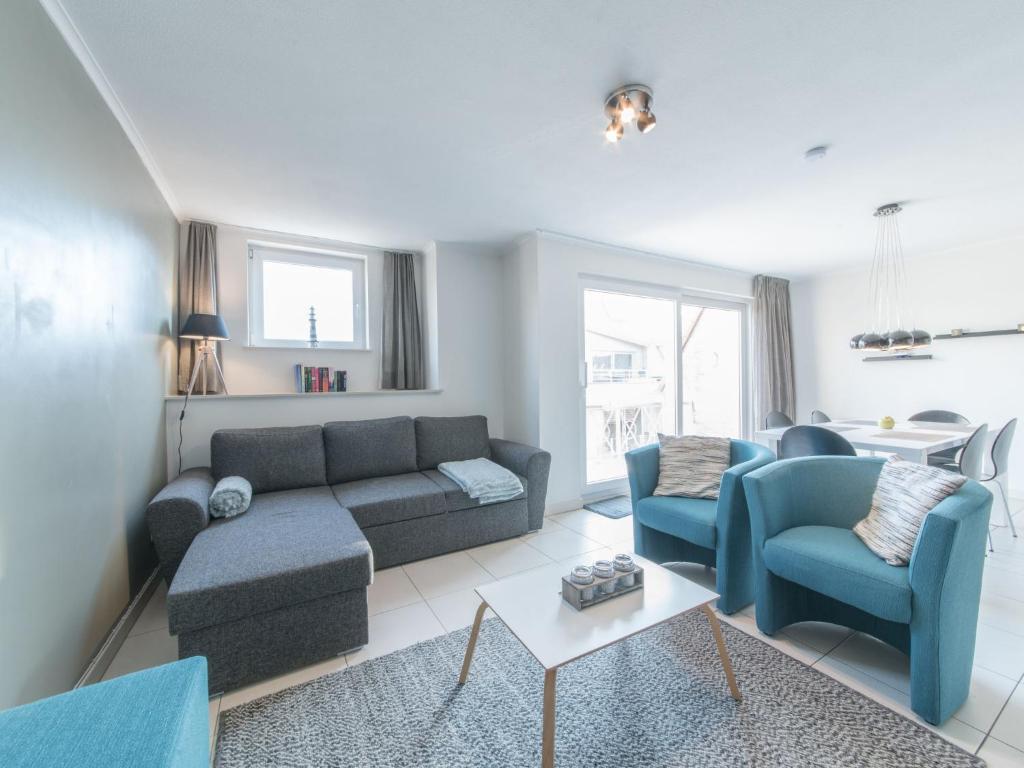 布列登Apartment Residentie Duinenbries-1 by Interhome的客厅配有沙发、椅子和桌子