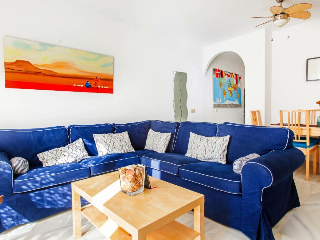托雷德本纳贾尔邦Apartment Edif- Museo 2ºk by Interhome的客厅配有一张蓝色的沙发,配有一张桌子