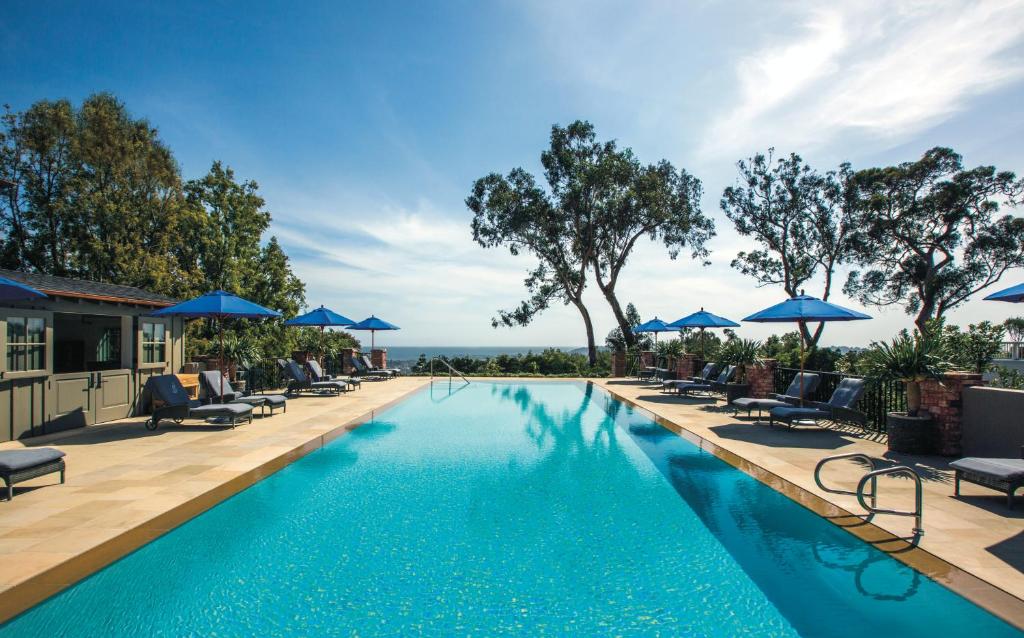 圣巴巴拉El Encanto, A Belmond Hotel, Santa Barbara的一个带躺椅和遮阳伞的游泳池