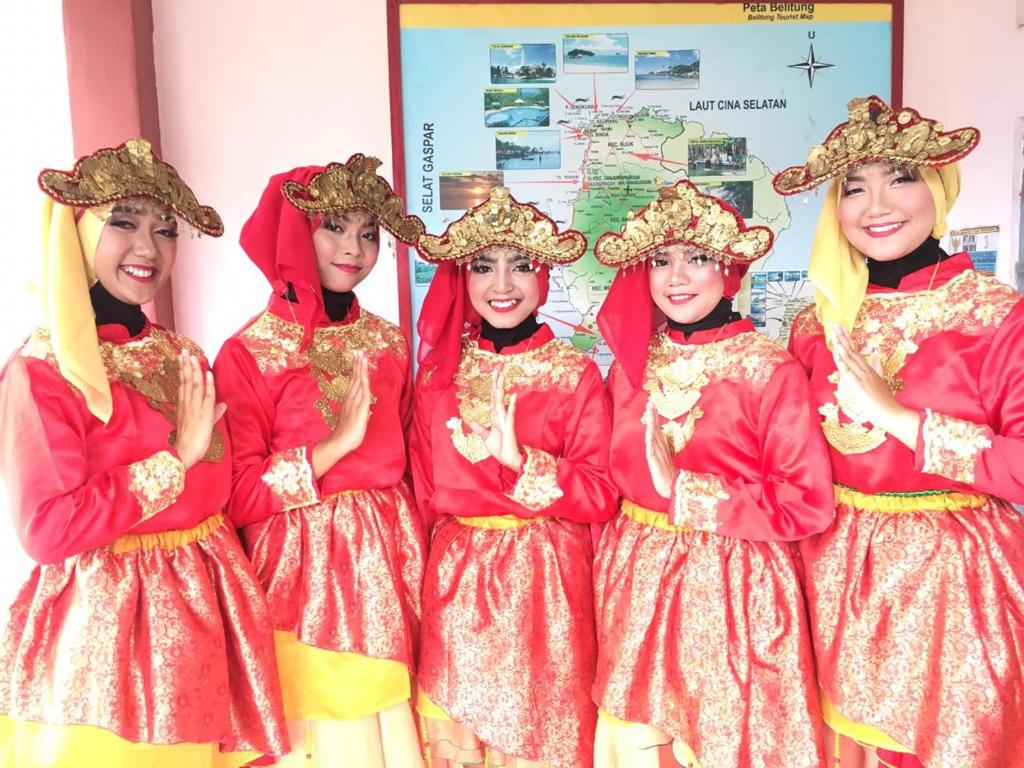 丹戎潘丹Belitung Backpacker的一群穿着红色和金色的年轻女孩