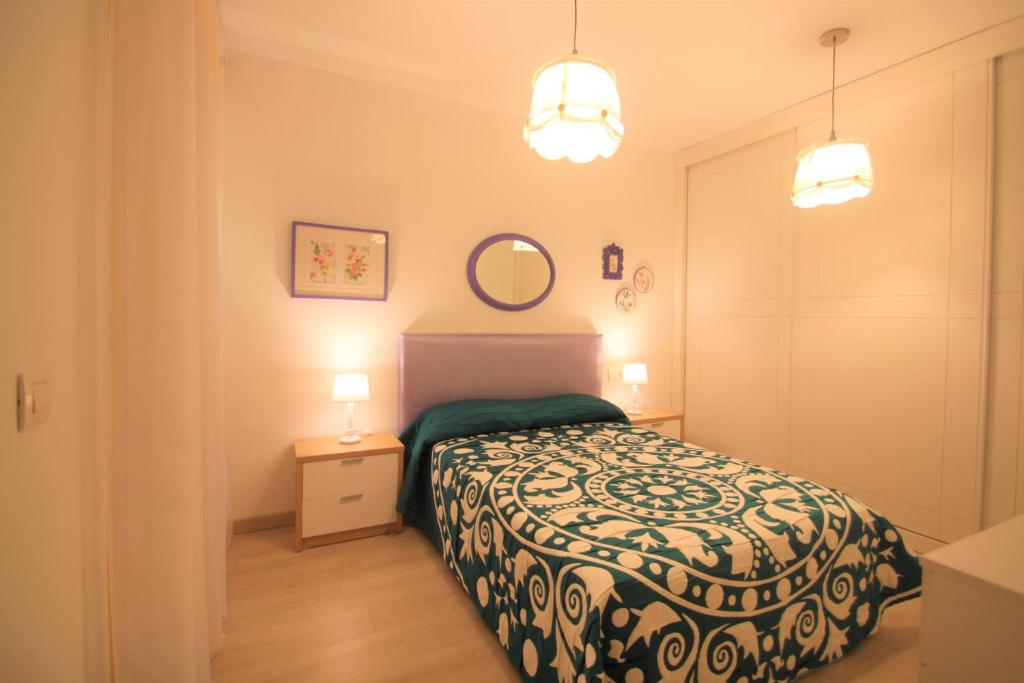 阿利坎特Apartamento CasaTuris cerca del aeropuerto de El Altet AT101的一间小卧室,配有床和两盏灯