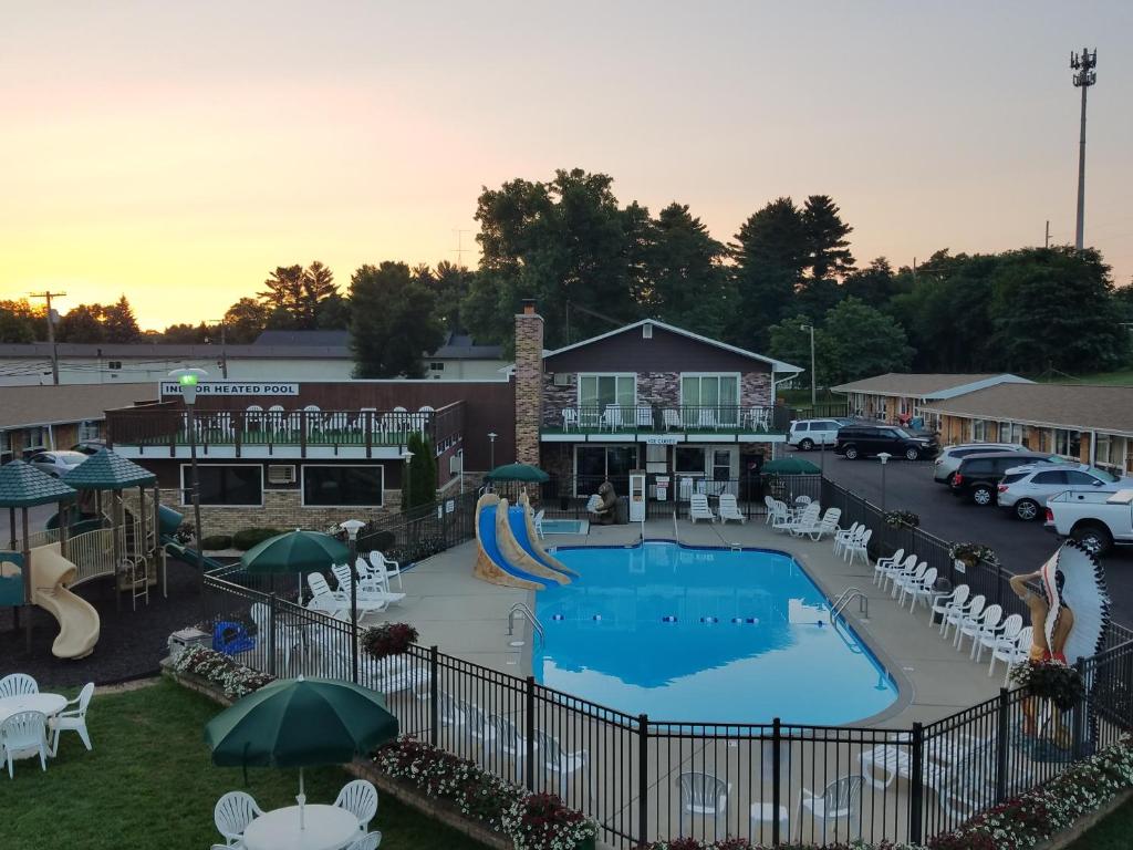 威斯康星戴尔Black Hawk Motel & Suites的一个带滑梯和椅子的室外游泳池以及主题