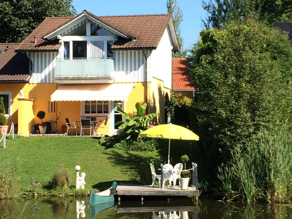 HergensweilerTraumferienhaus Pfänderblick mit 4 Sternen的水中带雨伞和船只的房子