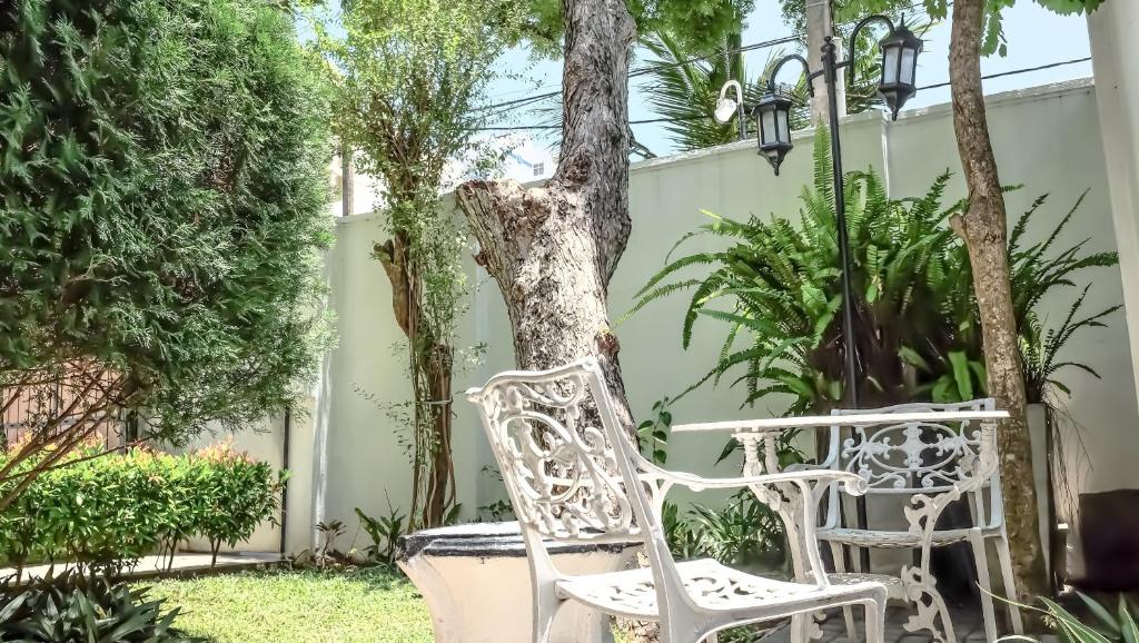 科伦坡Vivid Colombo的几把白色椅子坐在树边