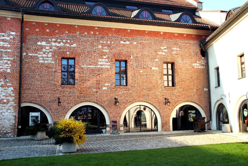 Tyniec多姆奥帕特瓦本尼迪克汽车旅馆的红砖建筑,设有拱门和窗户