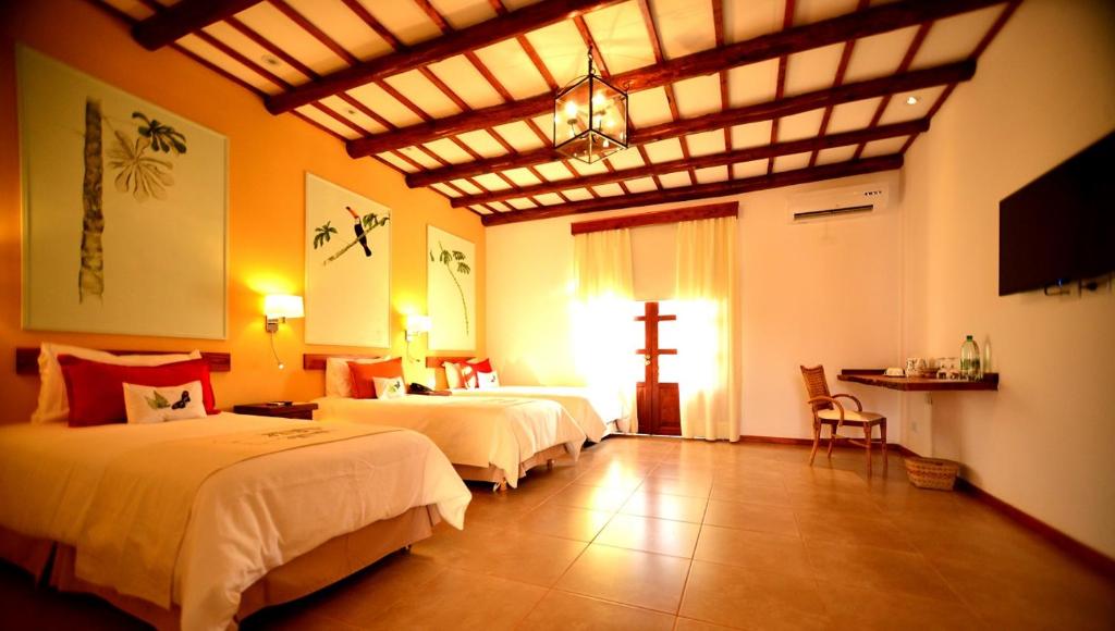 伊瓜苏港El Pueblito Iguazú的卧室配有两张床,墙上有一个十字架