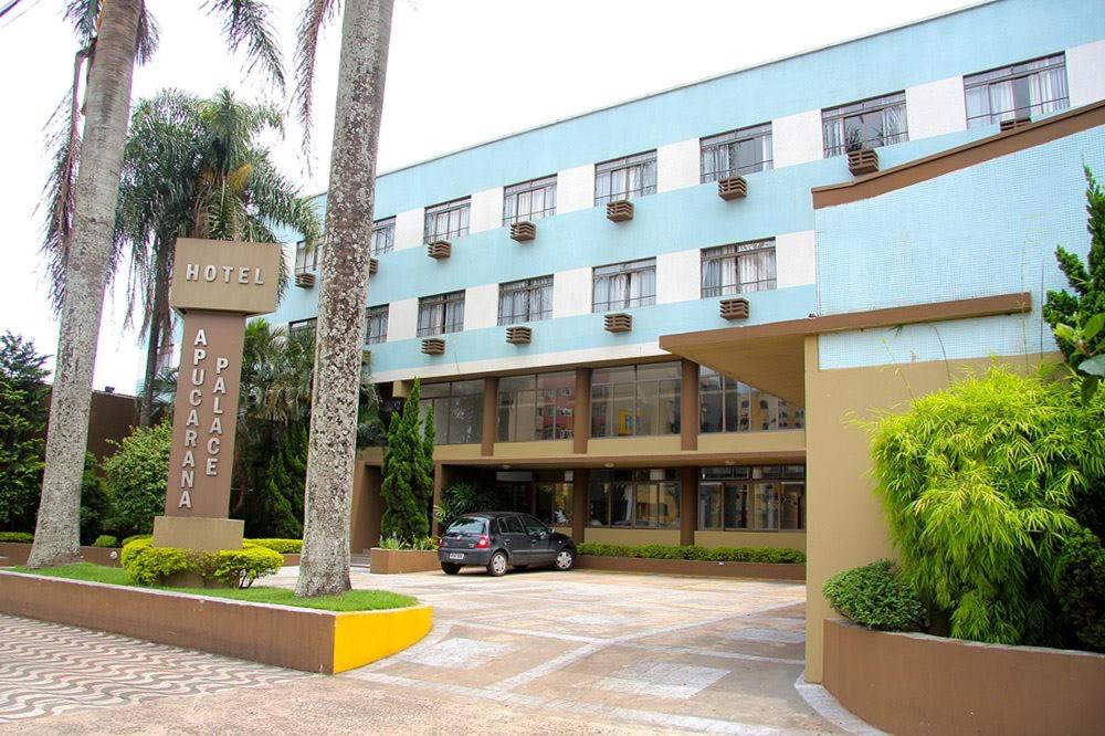 阿普卡拉纳Apucarana Palace Hotel的前面有停车场的酒店