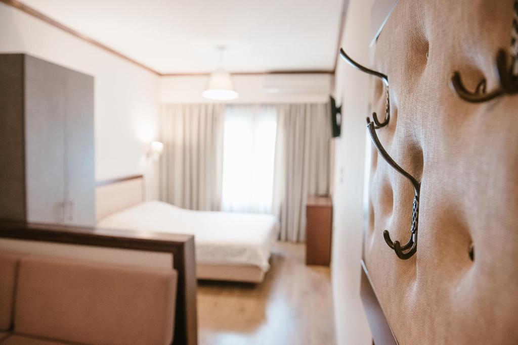 约阿尼纳肯翠康酒店的一间酒店客房,墙上有床和玻璃杯