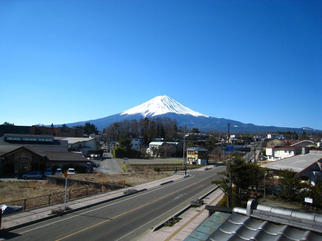 富士河口湖泰平馆酒店的一座有道路的城市的雪覆盖的山