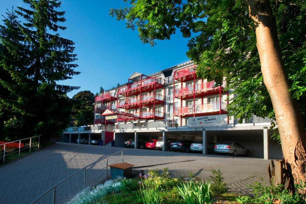 奥伯霍夫奥贝罗夫松恩航小木屋公寓式酒店的公寓大楼设有红色的阳台和停车场