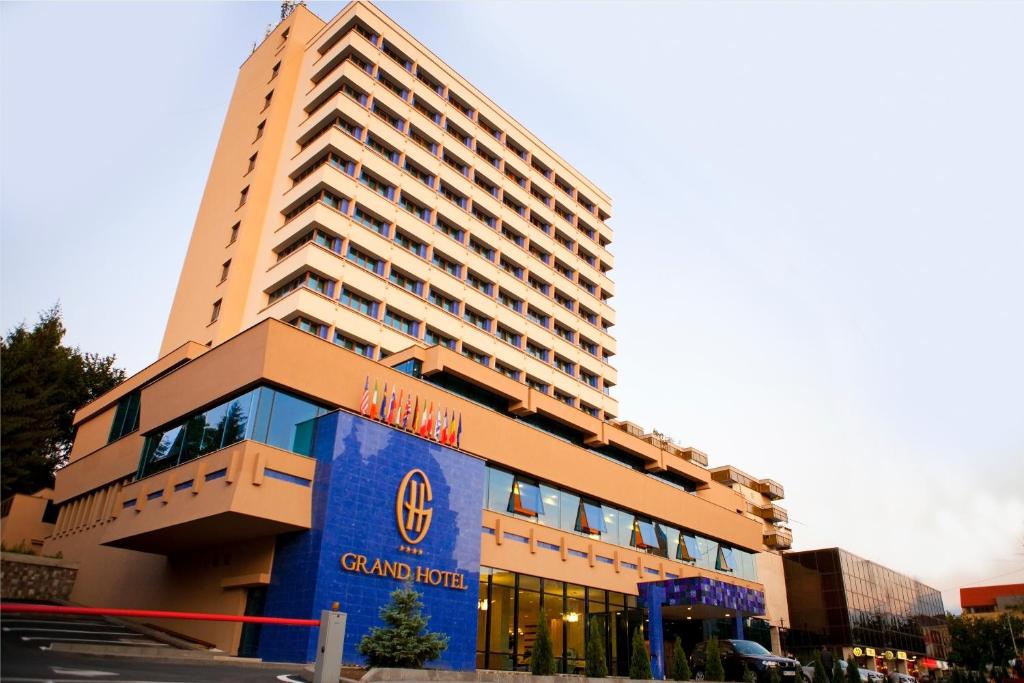 特尔古穆列什格兰德酒店的一座大型酒店建筑,上面有蓝色标志