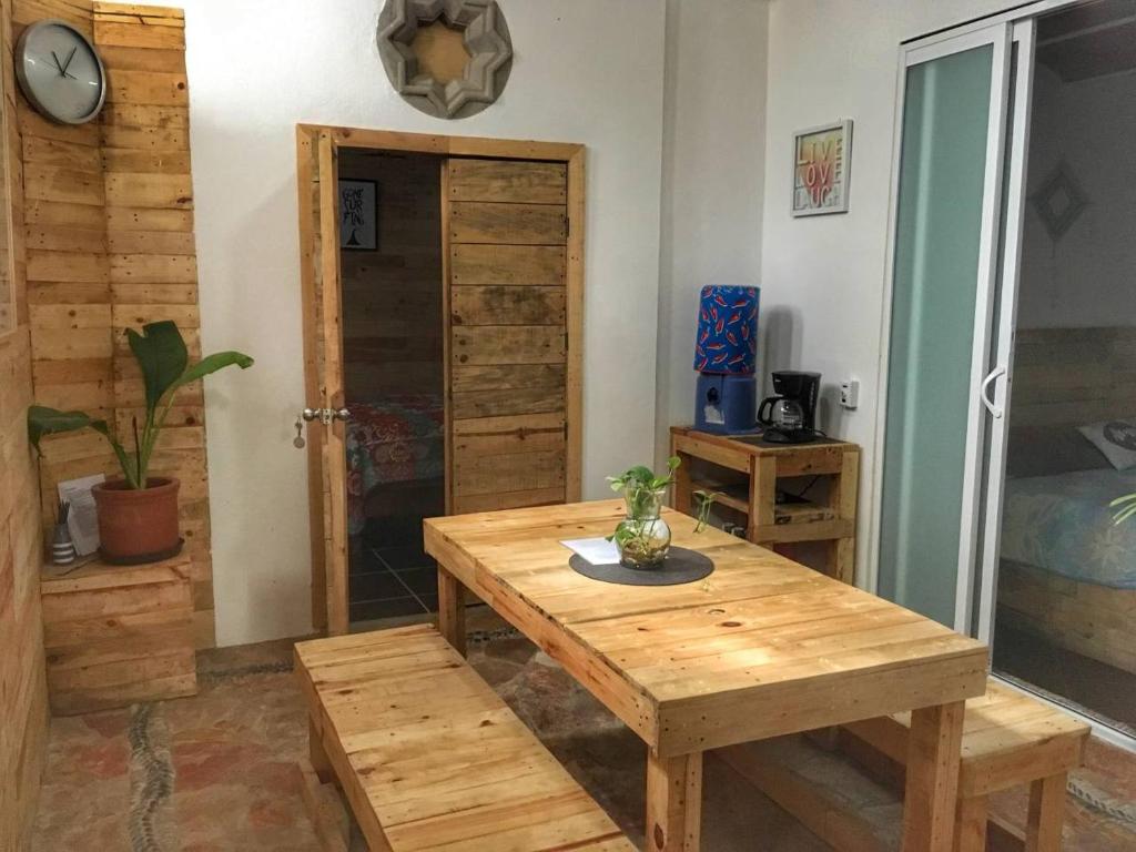萨尤利塔Apartamento Areca #的一张木桌和一张长凳,位于一间设有床铺的房间