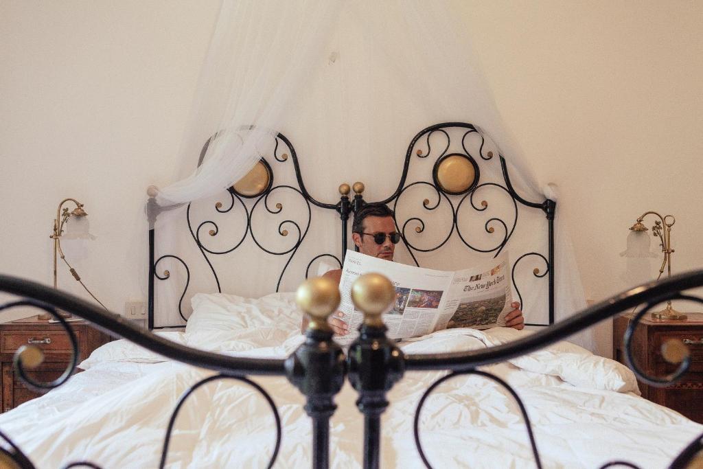 CasalzuignoAntico Borgo Sanda Lago Maggiore的坐在床上看报纸的人