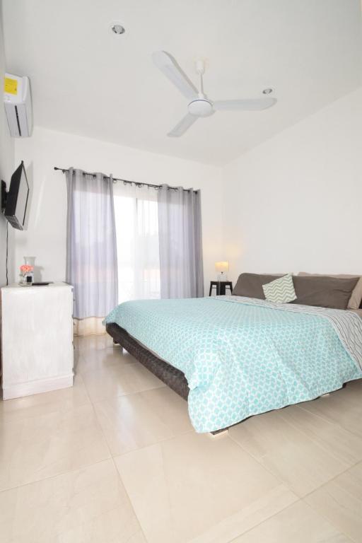 科苏梅尔Carlota Guest House的白色的卧室设有床和窗户